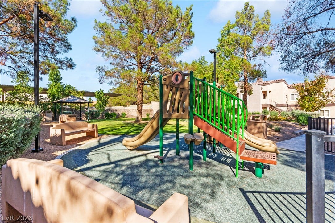 5250 S Rainbow Boulevard, #2033, Las Vegas, NV 89118 Mature trees surround a community play area equipped with a modern climbing structure.