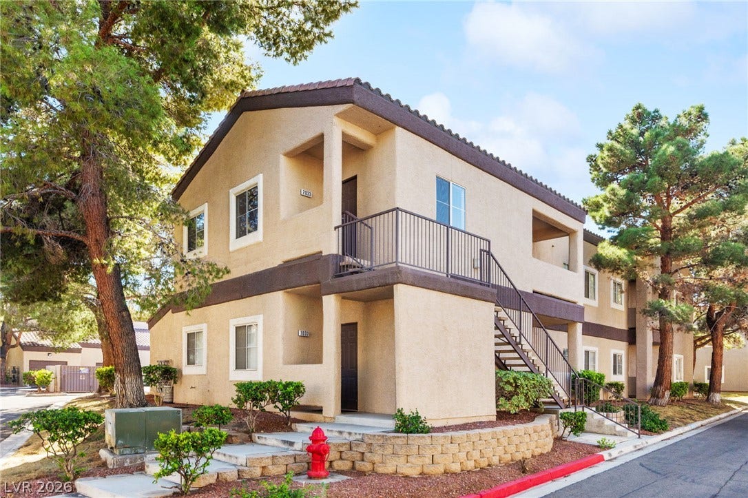 5250 S Rainbow Boulevard, #2033, Las Vegas, NV 89118 Stucco exteriors and a tiled roof define this multi-level residential building shaded by mature trees.
