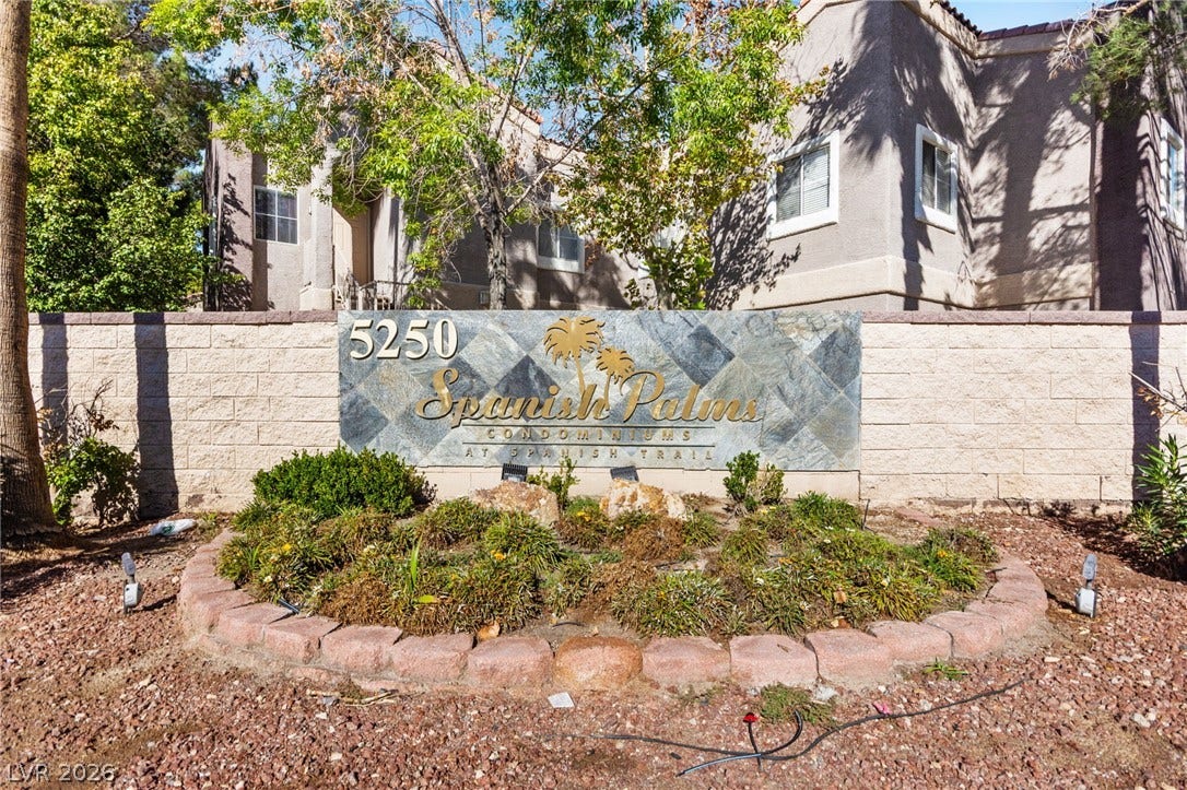 5250 S Rainbow Boulevard, #2033, Las Vegas, NV 89118 Mature trees and neat landscaping frame the stone entry monument sign of this multi-family residential building.