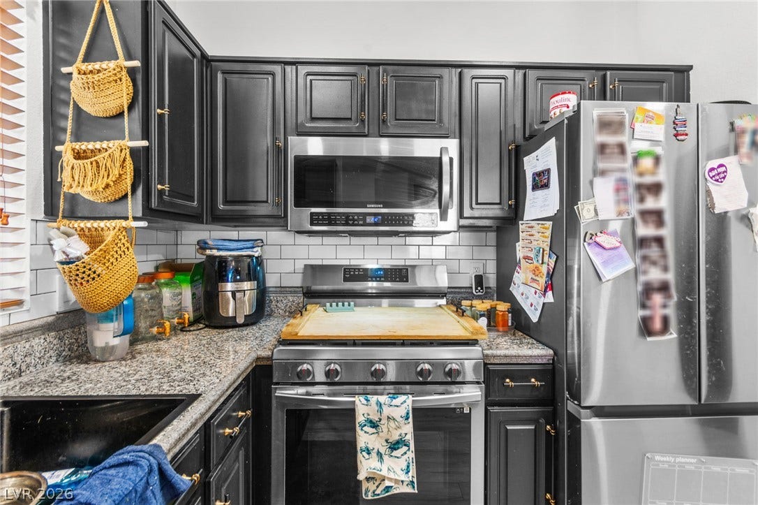 5250 S Rainbow Boulevard, #2033, Las Vegas, NV 89118 Dark cabinetry beautifully contrasts with granite countertops and stainless steel appliances.