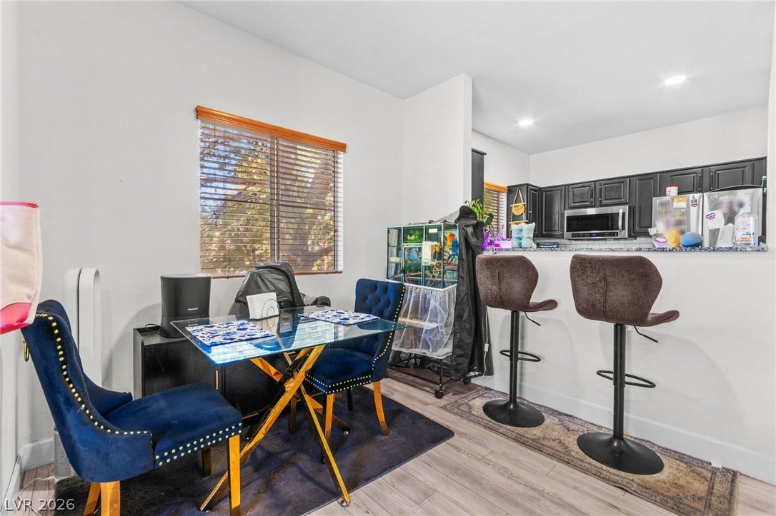 5250 S Rainbow Boulevard, #2033, Las Vegas, NV 89118 An open dining area flows seamlessly into the kitchen with modern wood-style flooring throughout.