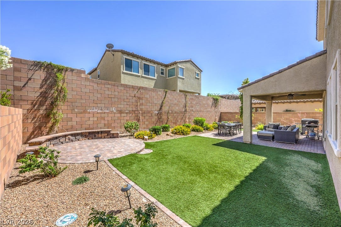 413 Via Gigante, Henderson, NV 89011 A well-appointed backyard offers both a covered patio and a separate paver seating area for diverse outdoor enjoyment.