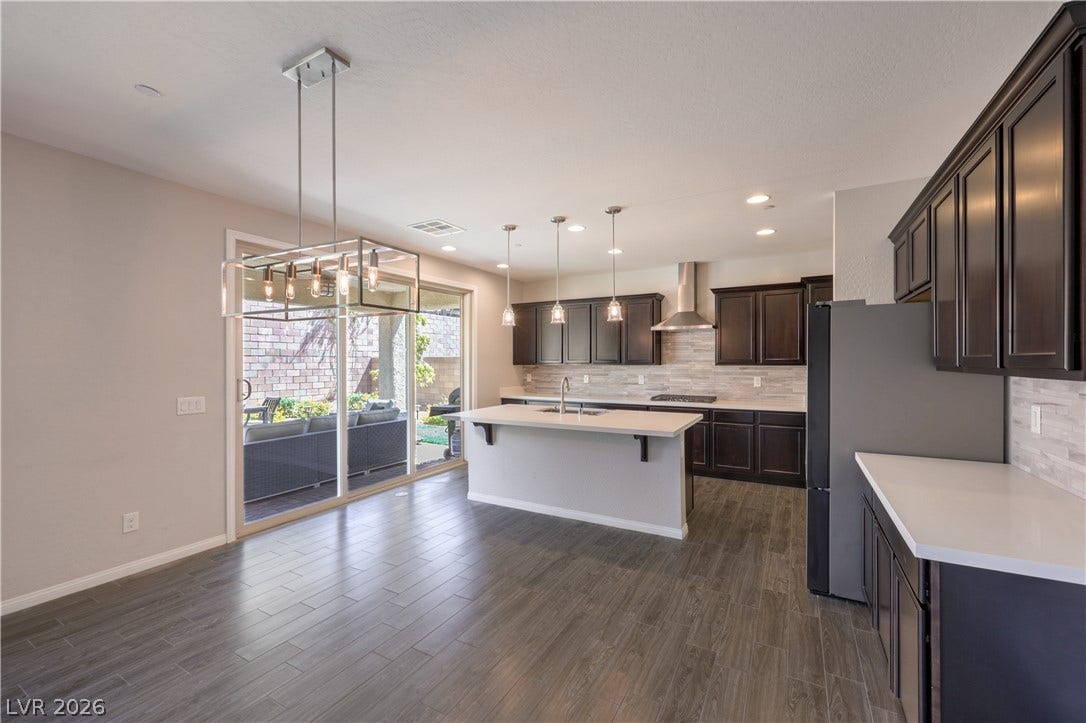 413 Via Gigante, Henderson, NV 89011 A sleek, contemporary kitchen with an island sink, abundant cabinetry, and seamless outdoor access.