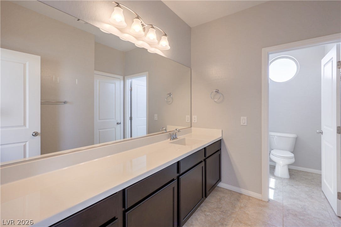 413 Via Gigante, Henderson, NV 89011 A well-lit primary bathroom vanity with generous counter space, dual sinks, and a separate water closet.