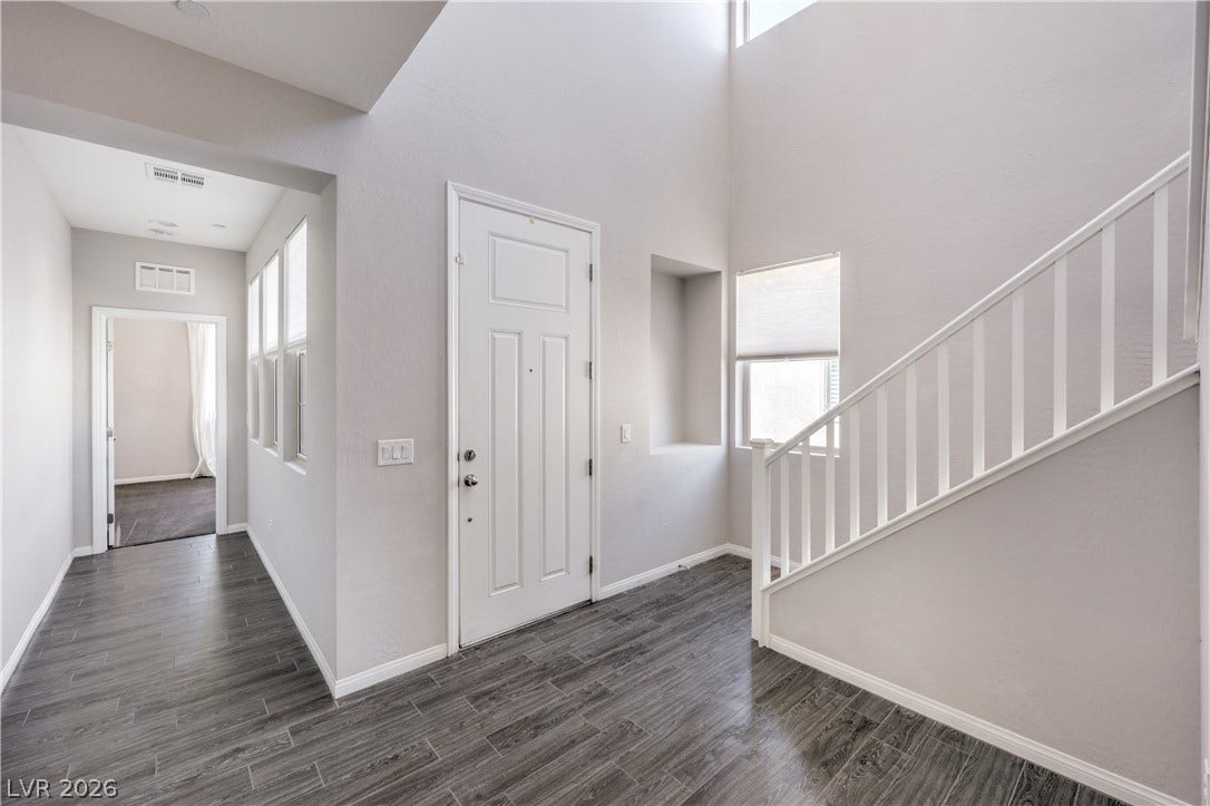 413 Via Gigante, Henderson, NV 89011 A welcoming entryway with soaring ceilings and rich tile flooring leads to a brightly lit hall and a contemporary staircase.