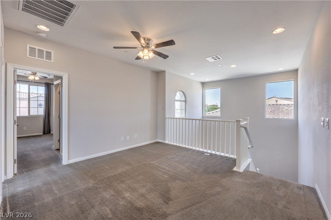 413 Via Gigante, Henderson, NV 89011 A versatile upstairs loft with carpeted floors and ample natural light, ideal for a flexible living space.