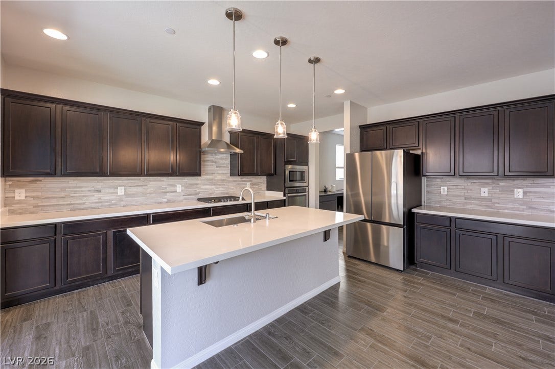413 Via Gigante, Henderson, NV 89011 Modern kitchen features a spacious island with sink and sleek stainless steel appliances.