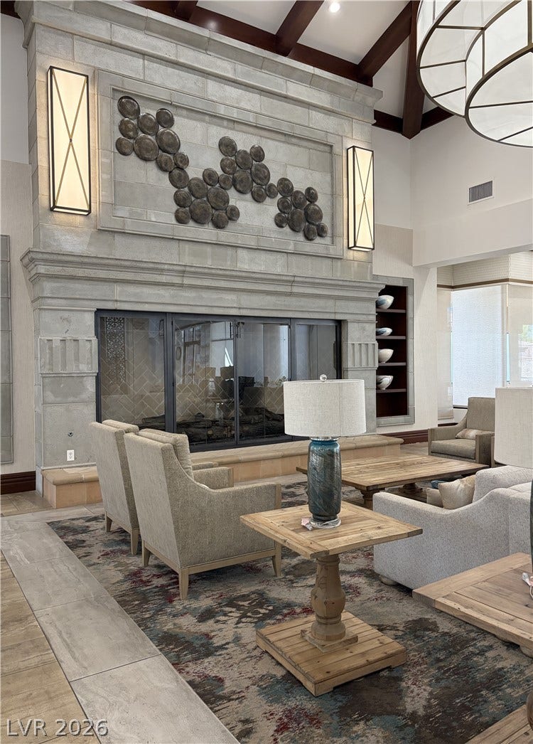 413 Via Gigante, Henderson, NV 89011 An imposing stone fireplace rises to meet the towering timber-beamed ceiling.
