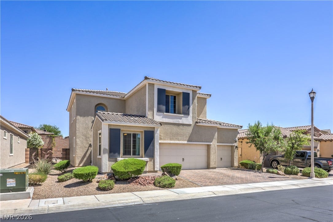 413 Via Gigante, Henderson, NV 89011 A well-maintained facade with multiple garages and decorative landscaping welcomes you home.
