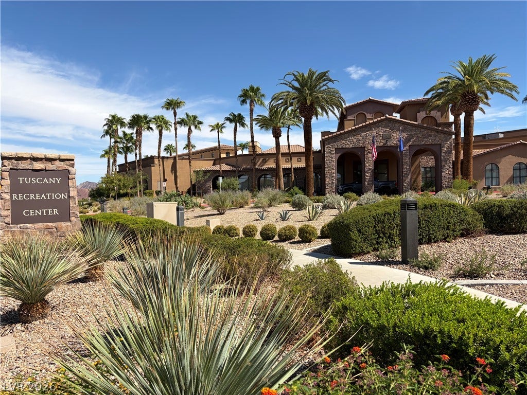 413 Via Gigante, Henderson, NV 89011 Palm trees and manicured desert landscaping frame the grand stone entryway of this community recreation center.