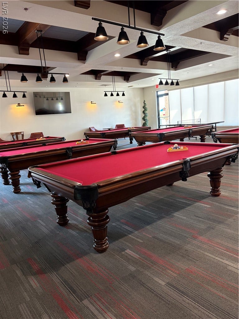 413 Via Gigante, Henderson, NV 89011 High ceilings and track lighting crown this expansive recreational space with patterned carpet flooring.