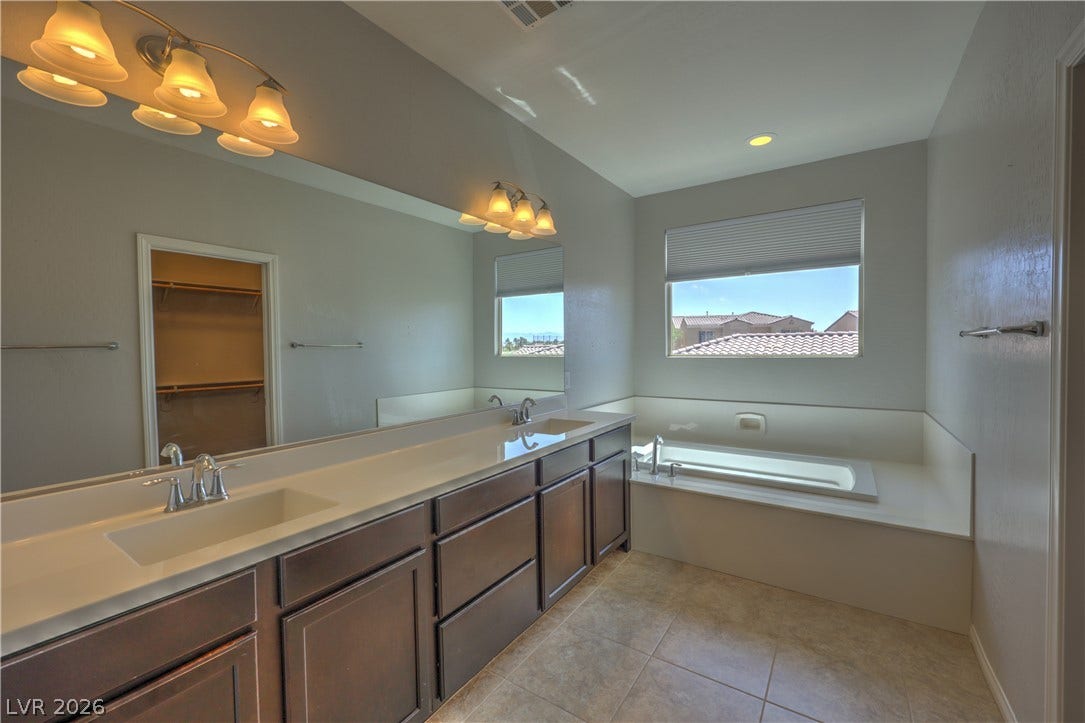 413 Via Gigante, Henderson, NV 89011 Indulge in a peaceful soak with a spacious tub and dual vanities, perfect for unwinding after a long day.