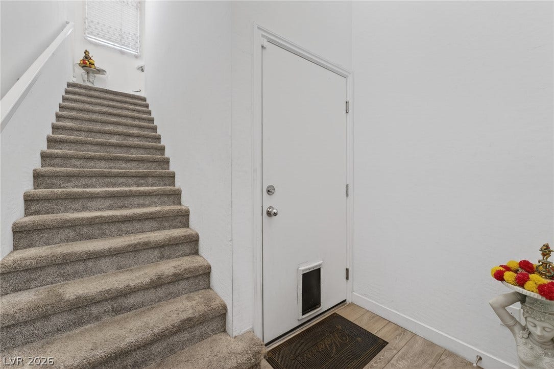 3700 Canis Minor Lane, #19206, Henderson, NV 89052 Carpeted stairs ascend alongside a bright entryway featuring durable plank flooring.