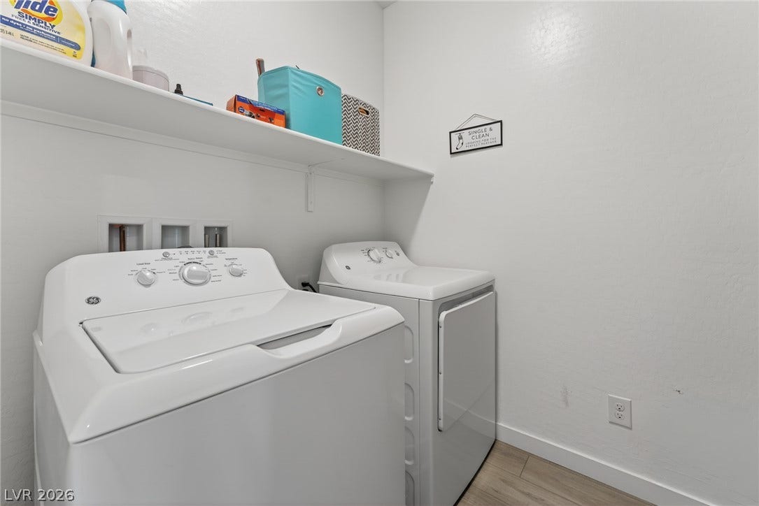 3700 Canis Minor Lane, #19206, Henderson, NV 89052 An organized laundry space features wood flooring and a convenient storage shelf.