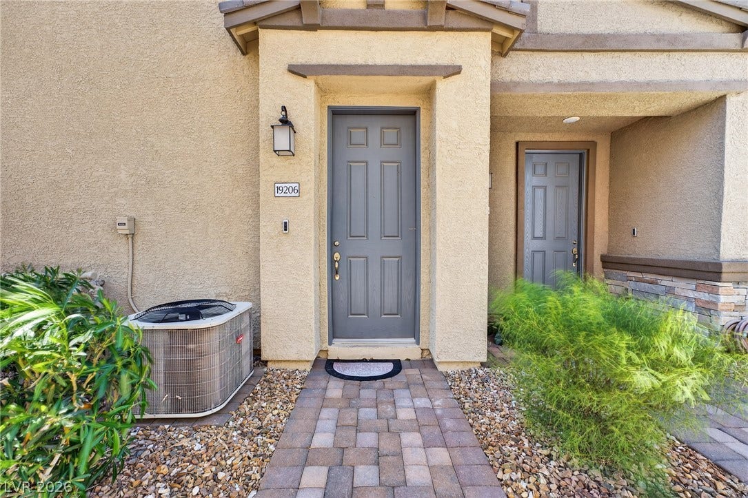 3700 Canis Minor Lane, #19206, Henderson, NV 89052 An inviting stone paver walkway leads to a classic covered entryway with stucco walls.