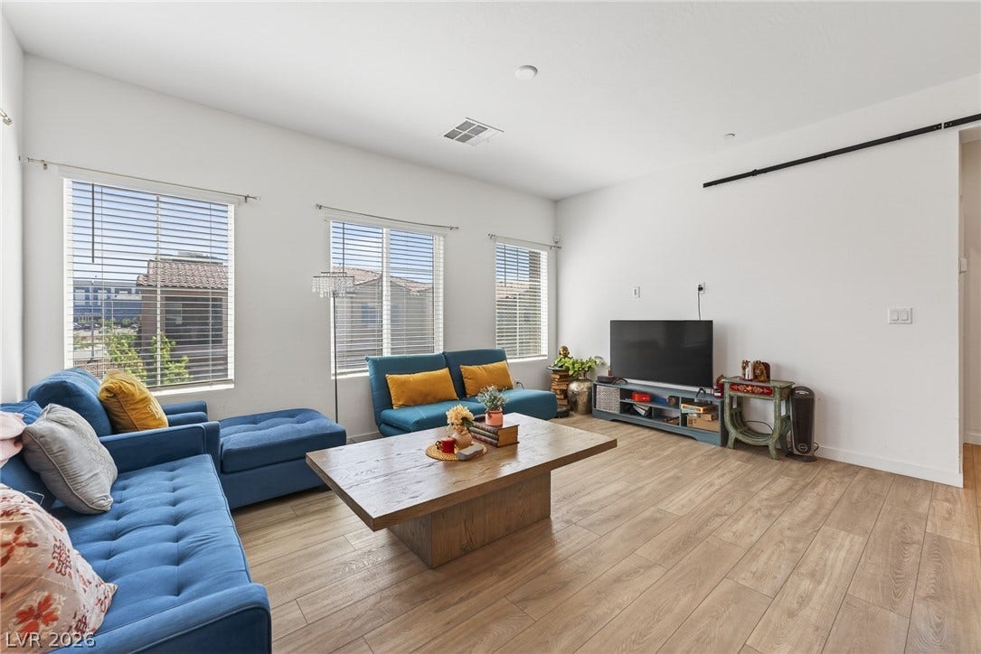 3700 Canis Minor Lane, #19206, Henderson, NV 89052 Natural light streams through multiple windows highlighting the spacious layout and warm wood flooring.