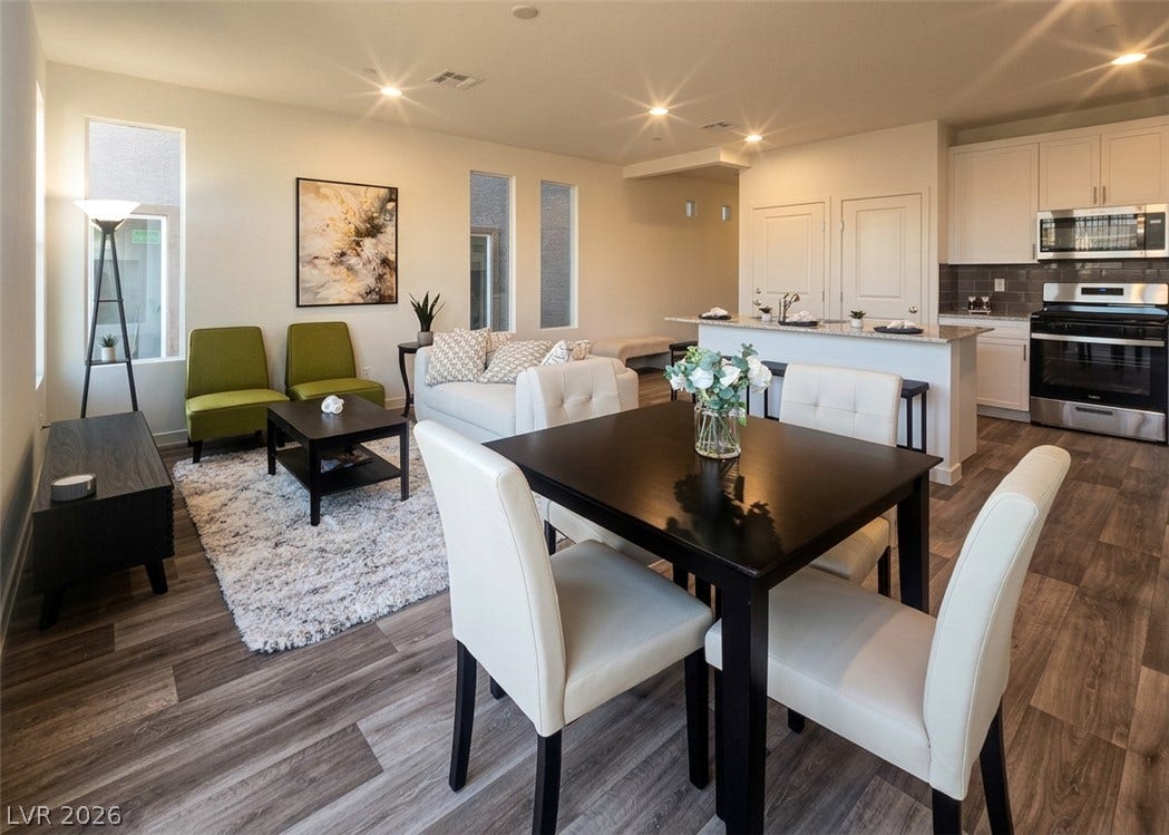 4914 Sweet Vesper Court, Las Vegas, NV 89108 An open-concept living area flows into a dining space and modern kitchen with wood-look flooring.