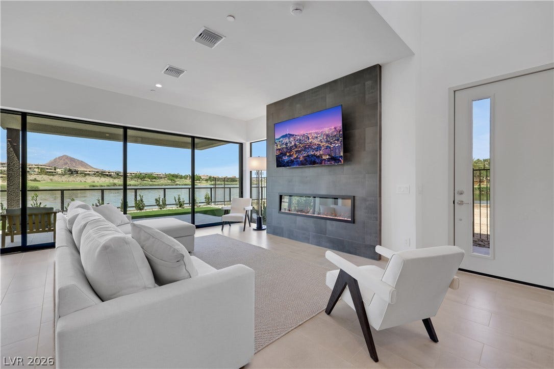 66 Lakefront Drive, Henderson, NV 89011 Floor-to-ceiling windows frame a stunning lakeside vista in this inviting living space.