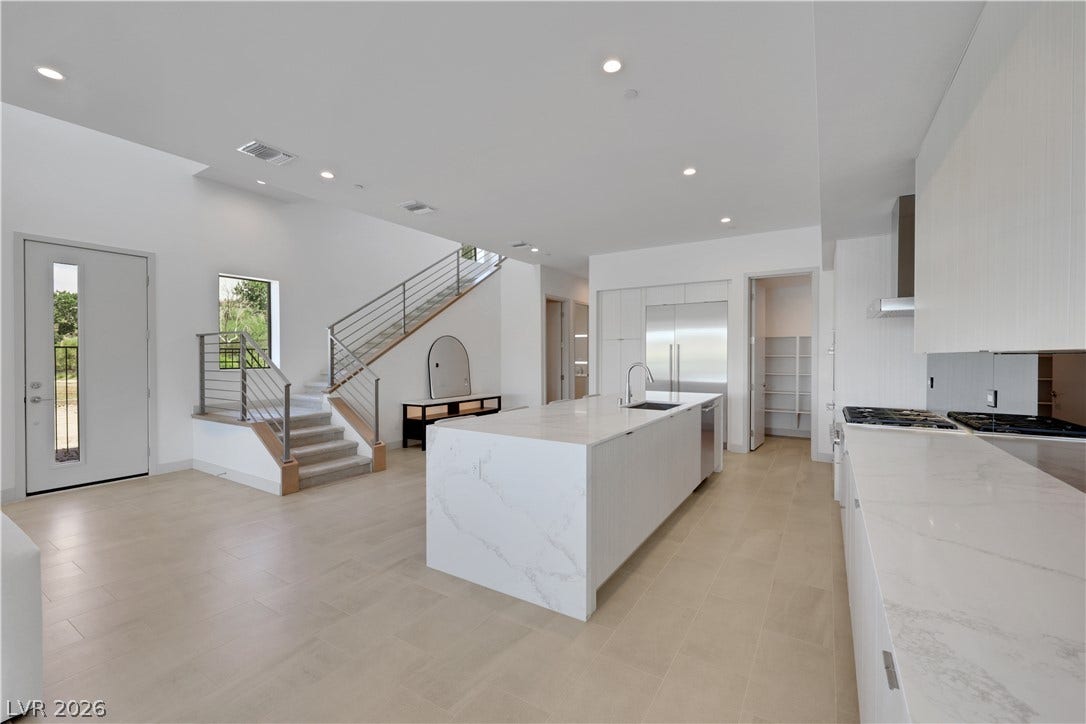 66 Lakefront Drive, Henderson, NV 89011 A striking kitchen island with sleek white countertops anchors this contemporary open-concept space.