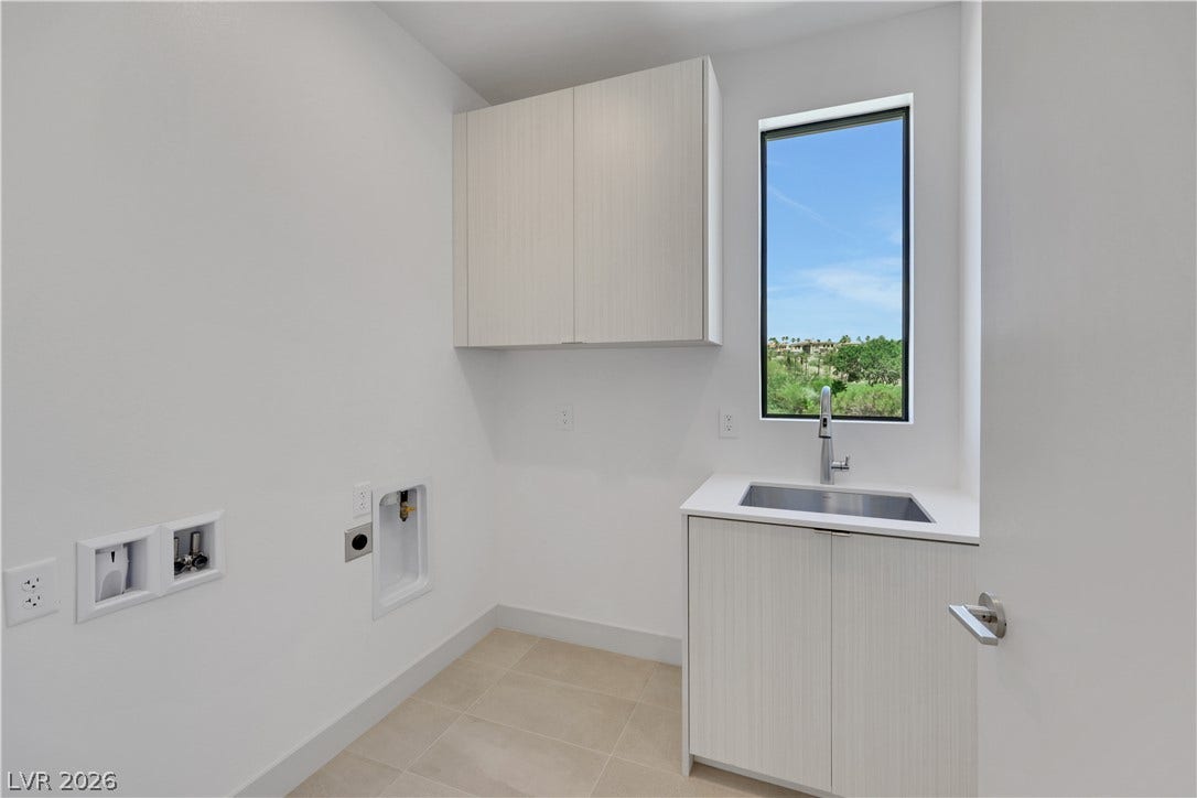 66 Lakefront Drive, Henderson, NV 89011 A well-appointed utility area featuring cabinetry, a sink, and a framed outdoor vista.