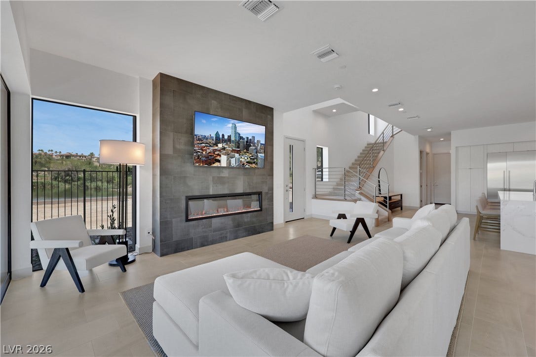 66 Lakefront Drive, Henderson, NV 89011 A refined living space showcases an elegant fireplace, tall ceilings, and a view of the outside.
