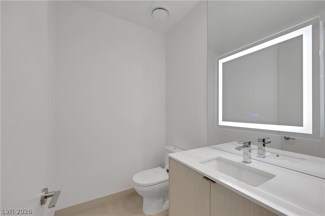 66 Lakefront Drive, Henderson, NV 89011 A well-appointed lavatory featuring a contemporary illuminated mirror and sleek vanity.