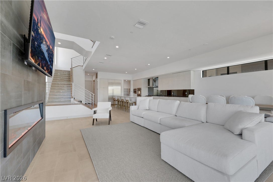 66 Lakefront Drive, Henderson, NV 89011 Seamlessly blending modern aesthetics, this open-concept living area offers a sophisticated experience with a sleek fireplace and integrated kitchen.