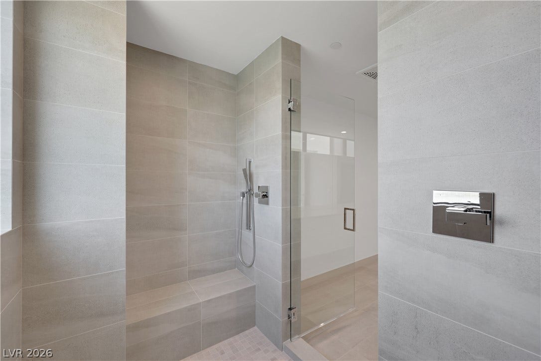 66 Lakefront Drive, Henderson, NV 89011 A streamlined shower features large format tiles and a built-in bench for comfort.