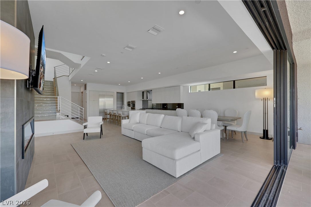 66 Lakefront Drive, Henderson, NV 89011 An open concept living area boasts a sleek fireplace, recessed lighting, and tile flooring.