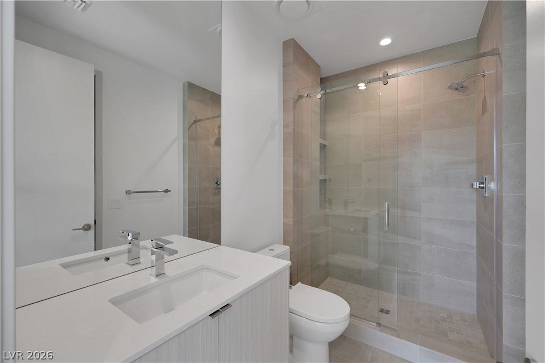 66 Lakefront Drive, Henderson, NV 89011 A well-appointed bathroom features a sleek vanity, contemporary fixtures, and a spacious glass-enclosed shower.