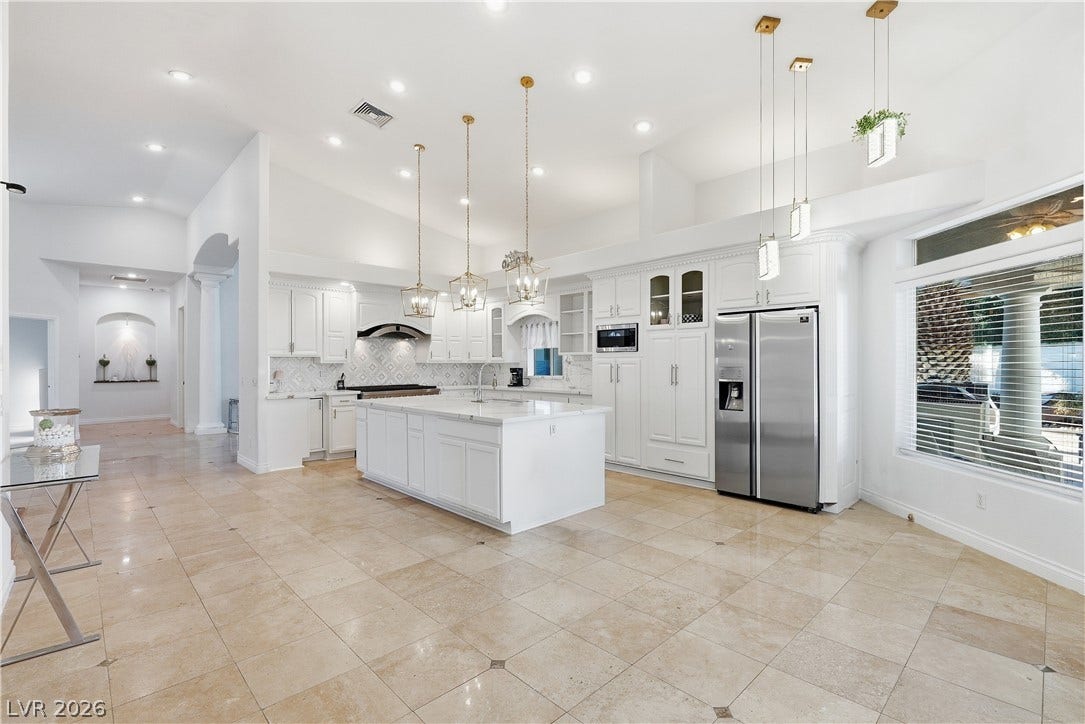 Gleaming tile floors and soaring ceilings elevate this spacious kitchen with a central island.