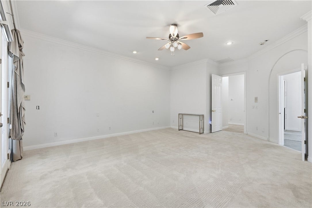 Crown molding and plush carpet frame this versatile living space.