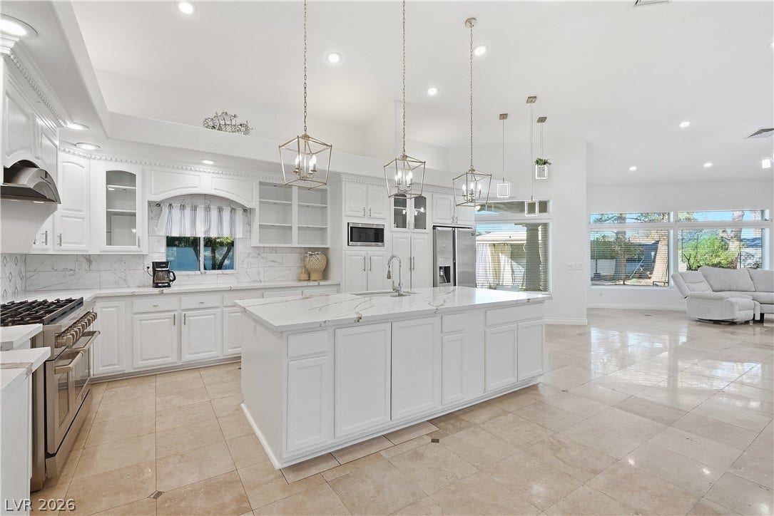Polished tile flooring and custom cabinetry anchor a spacious open-concept culinary layout.