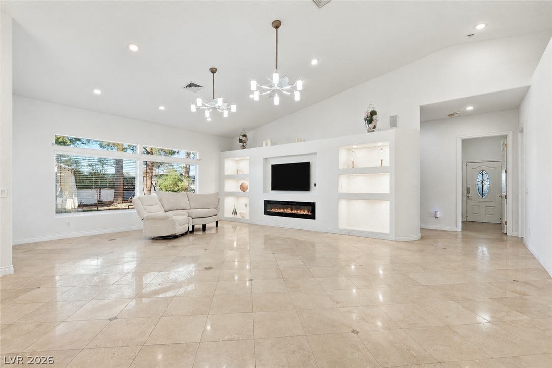 Gleaming tile floors and custom built-ins frame a contemporary living space with soaring ceilings.