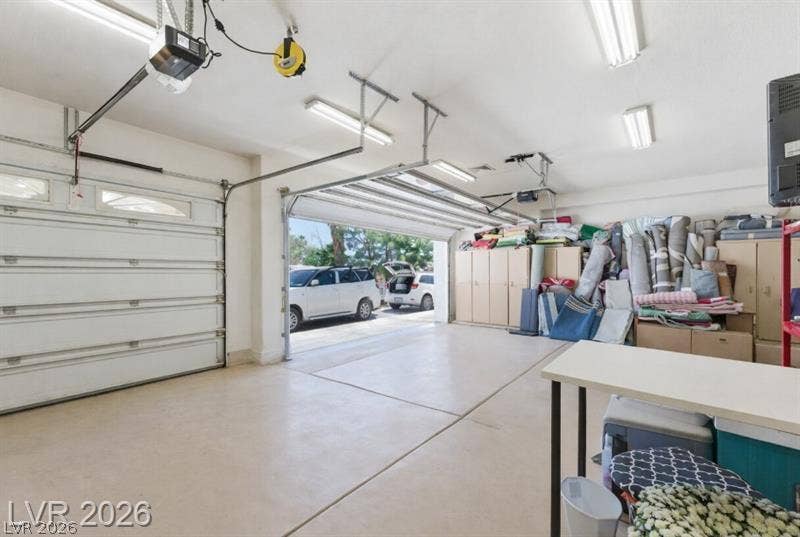 An accommodating multi-car garage provides extensive built-in storage cabinets and durable concrete flooring.