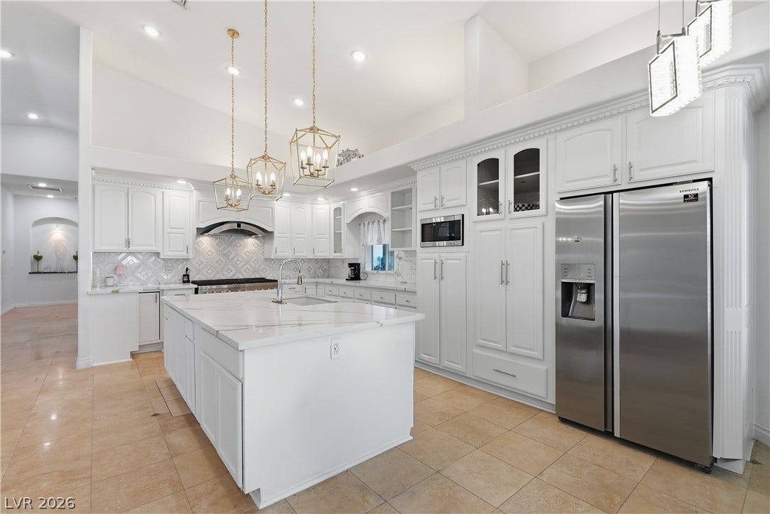 High ceilings and a stone-topped island define this spacious kitchen.