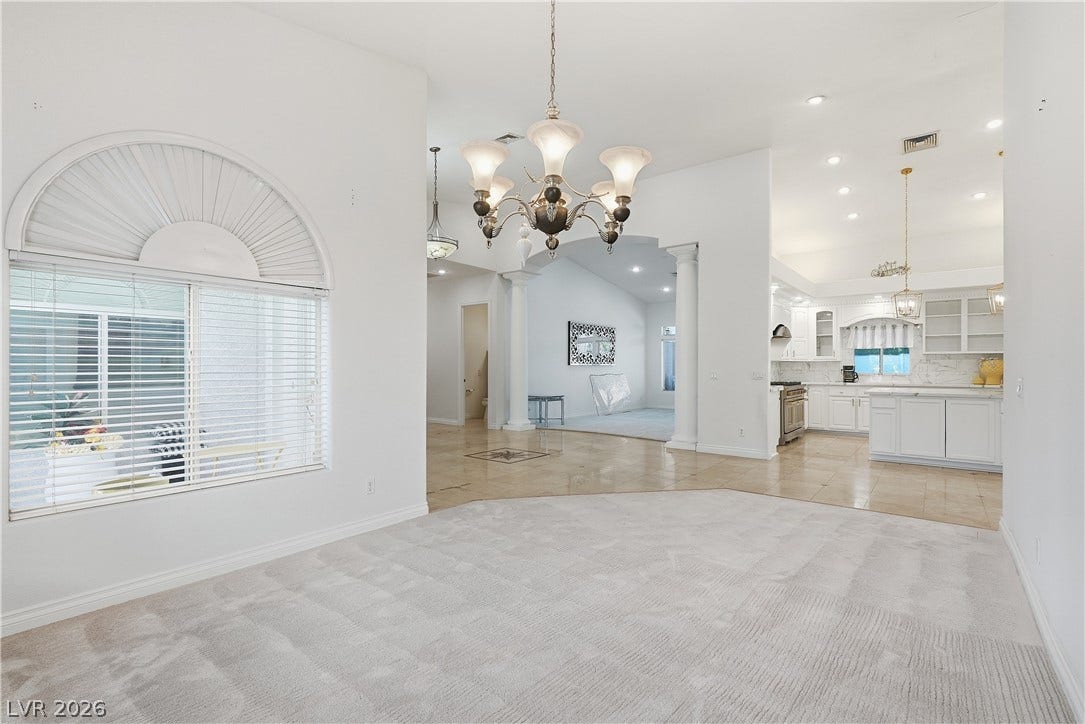 An open floor plan connects the carpeted living space directly to the kitchen.