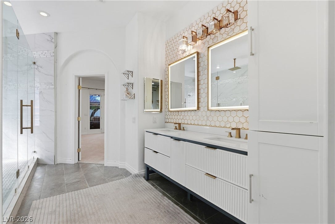 Graceful arched doorways and a double vanity define this elegant primary bathroom retreat.