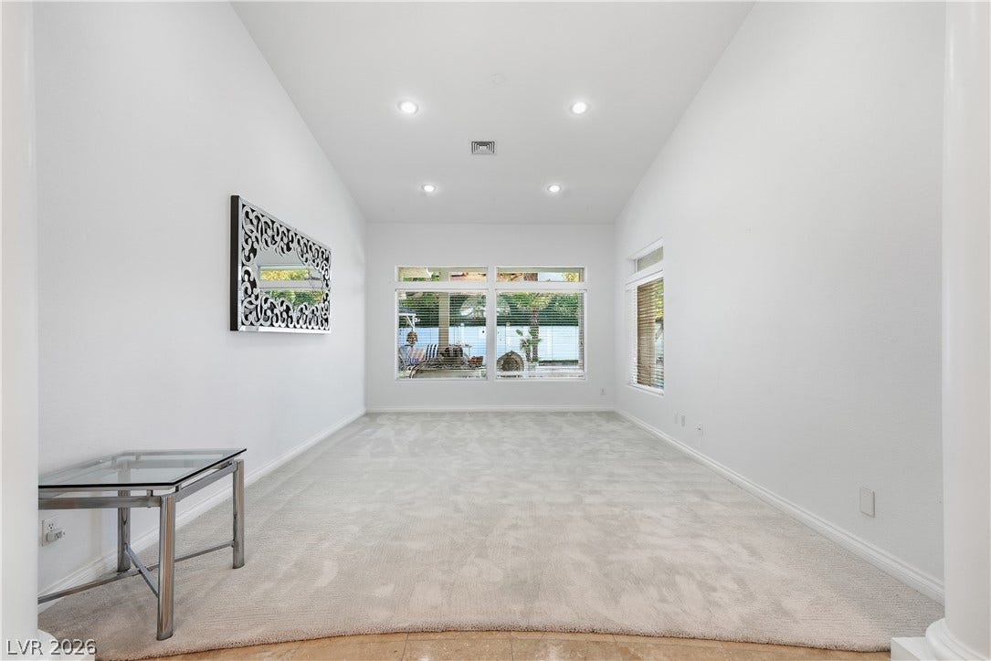 High ceilings and soft carpeting define this light-filled room framing garden views.