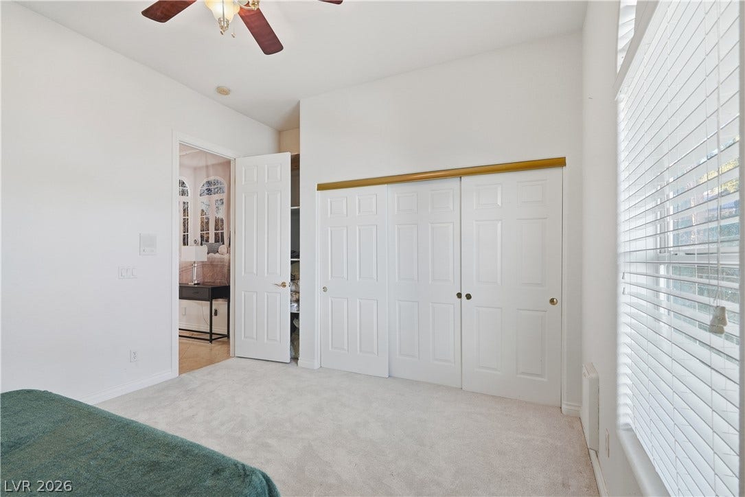 High ceilings and soft carpeting define this inviting secondary bedroom with ample closet storage.