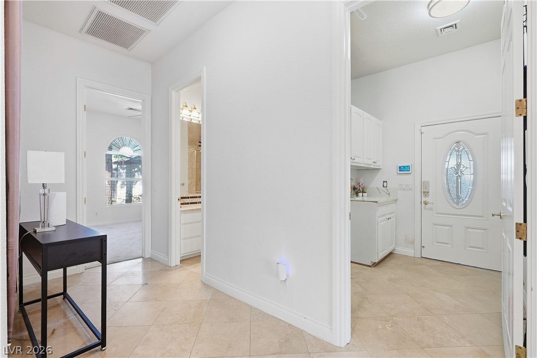 High ceilings and neutral tile flooring flow throughout this bright entryway and hall.