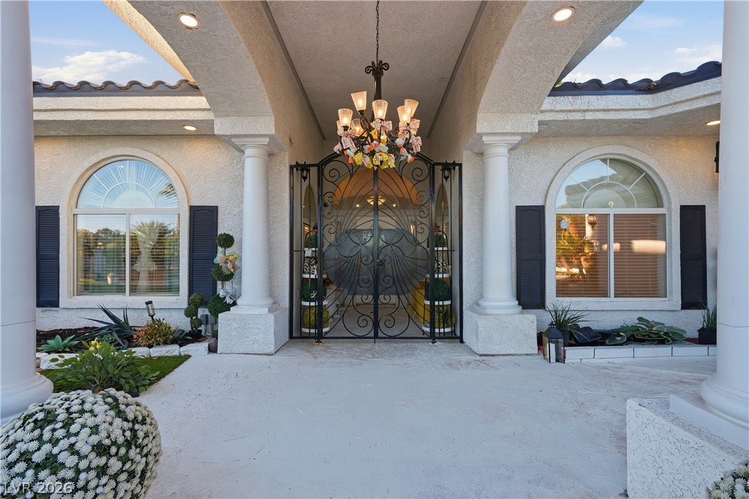 Stately pillars and an ornate iron gate create an unforgettable first impression at this entrance.