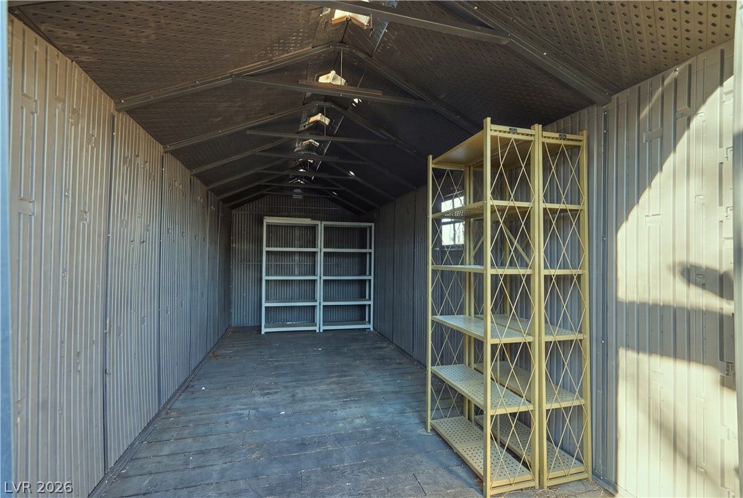 A spacious utility shed offers wood floors and ample room for storage organization.