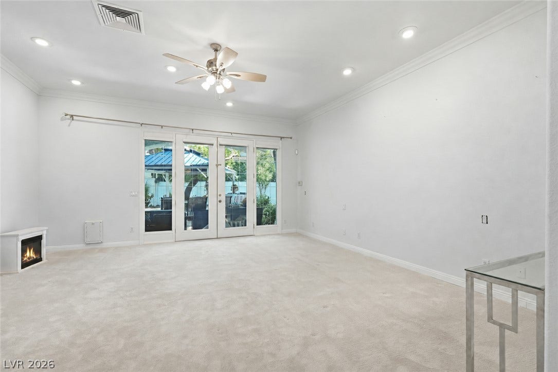Glass doors open to the outdoor patio from this carpeted living area.