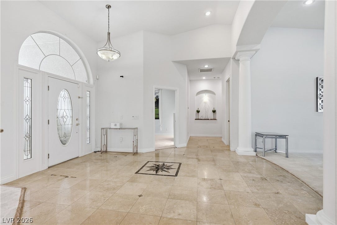 Gleaming tile floors and soaring ceilings define this airy foyer entrance.