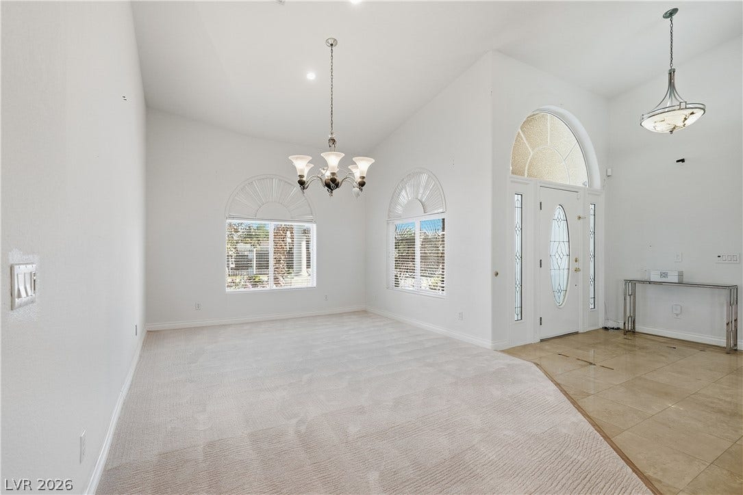 Arched windows and towering ceilings create an inviting, airy entrance to this elegant interior space.