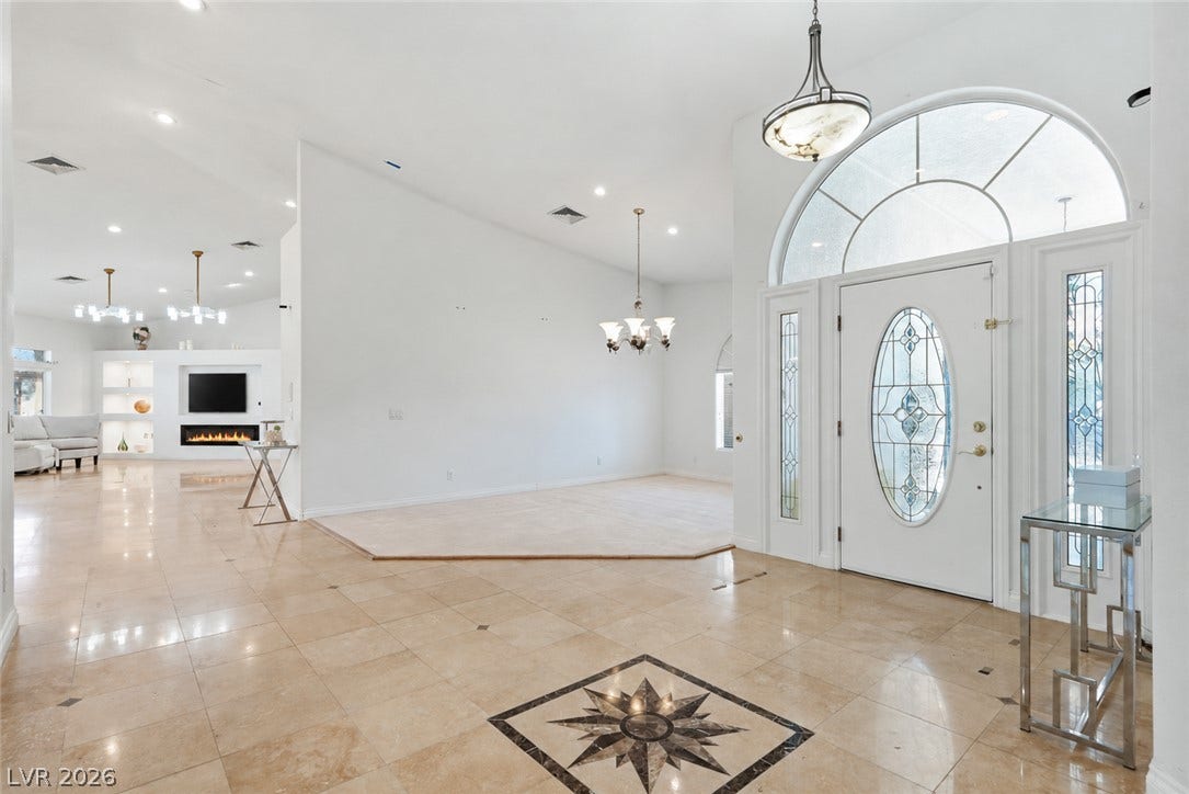 Gleaming tile floors with a decorative inlay welcome visitors into this grand open foyer.
