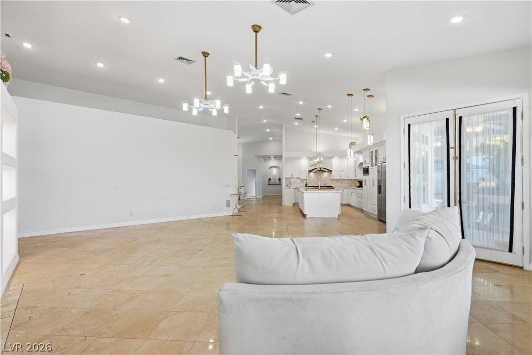 Polished tile flooring and double glass doors define this airy, open-concept living space.