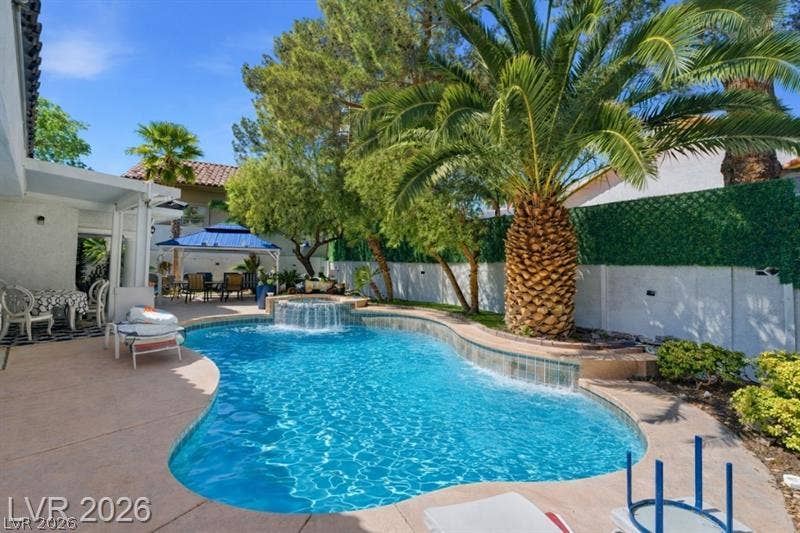 A sparkling swimming pool with a raised spa highlights this private backyard oasis.