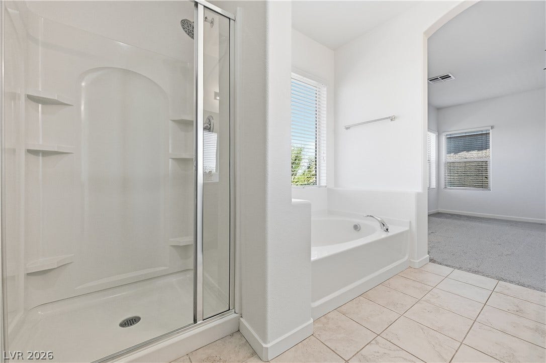 1122 Bradley Bay Avenue, Henderson, NV 89014 Tiled flooring and a separate soaking tub create a functional layout in this bathroom.